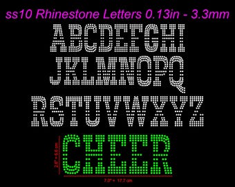 Könnte beinhalten: Schwarzer Hintergrund mit weißen Strassbuchstaben des Alphabets, plus dem Wort "CHEER" in grünen Strasssteinen. Die Buchstaben sind 3,3 mm groß. Das Wort "CHEER" ist 6,6 cm x 17,7 cm groß.