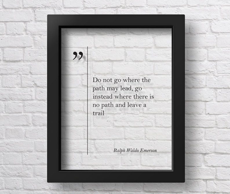 May include: Black framed print with a white background and black text. The text reads "Do not go where the path may lead, go instead where there is no path and leave a trail." The text is attributed to Ralph Waldo Emerson.