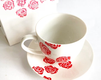 Tazzina da caffè con rose rosse disegnata a mano.