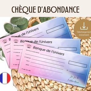 Op de afbeelding: Drie printbare 'Bank of the Universe' cheques met een roze en blauwe aquarel achtergrond. De cheques hebben velden voor het bedrag, de begunstigde, de memo en de datum. De tekst 'Wet van Overvloed' staat onderaan de cheque.