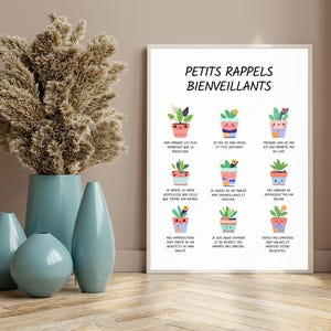 May include: A framed print with the text "PETITS RAPPELS BIENVEILLANTS" and illustrations of potted plants. A collection of blue vases and a vase with dried flowers are in the foreground.