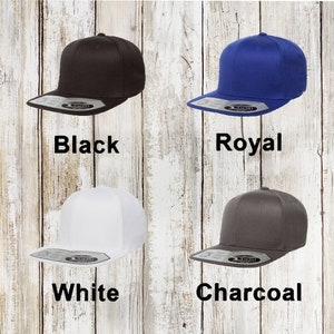 A collection of custom snapback hats. The collection includes colors: Black, charcoal, royal and white.