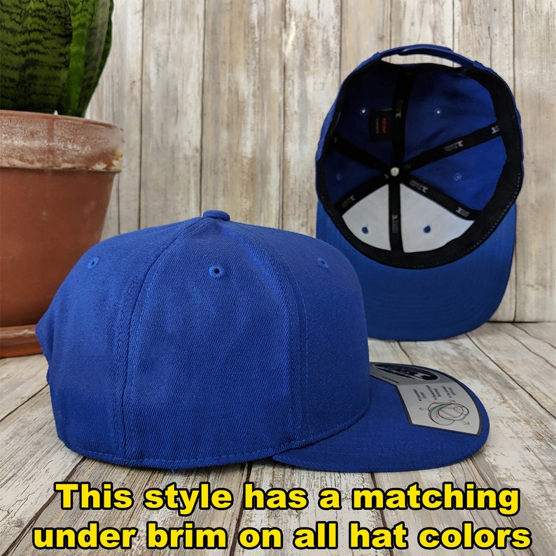 May include: A royal blue baseball cap with a matching under brim. The cap is made of a soft, comfortable fabric and has a classic, timeless design.