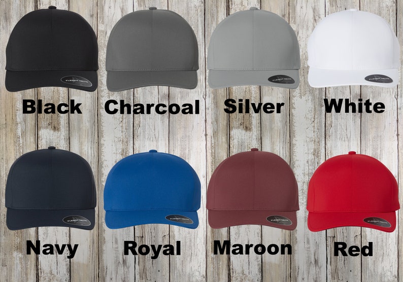 May include: A set of ten baseball caps in various colours, including black, charcoal, silver, white, navy, royal, maroon, and red. The caps are all the same style, with a curved brim and a flat crown.
