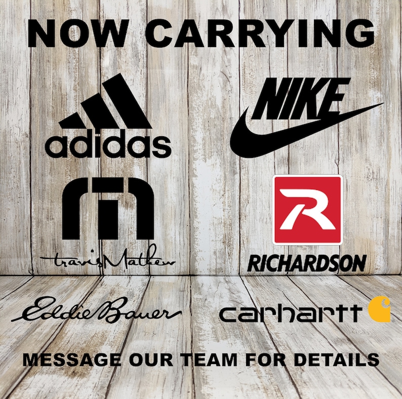 Op de afbeelding: Een houten achtergrond met de tekst "NOW CARRYING" in zwarte letters. Onder de tekst staan logo's van Adidas, Nike, Travis Mathew, Richardson, Eddie Bauer en Carhartt.