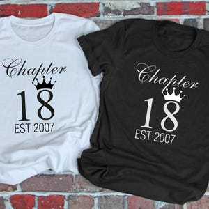 Peut inclure: Deux t-shirts, un blanc et un noir, avec le texte "Chapter 18 EST 2007" dans une police décorative. Une couronne est au-dessus du chiffre 18. Les chemises sont présentées sur un fond de mur de briques.