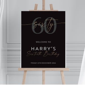 Puede incluir: Un letrero negro sobre un caballete de madera con el texto "60 Sixty" en escritura gris y dorada. Debajo, se lee "Welcome to Harry's Sixtieth Birthday" y la fecha "Viernes 6 de diciembre de 2024".