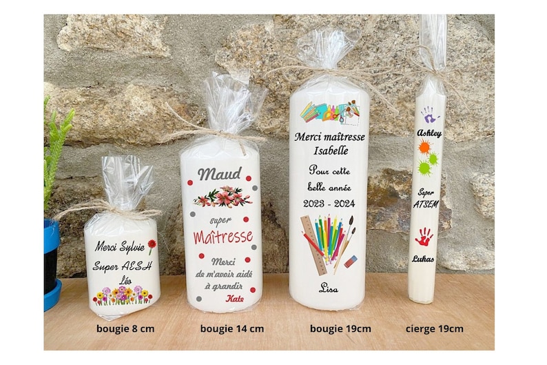 May include: Four white candles with personalized messages. The candles are decorated with colorful flowers, school supplies, and handprints. The candles are 8 cm, 14 cm, 19 cm, and 19 cm in length.