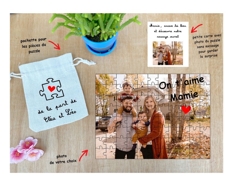 May include: A personalized jigsaw puzzle with a photo of a family of four in front of a house. The puzzle is in a white bag with a red heart and the text "de la part de El&eacute;a et L&eacute;o". The puzzle is titled "On t'aime Mamie" with a red heart.