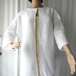 Jackan passar storlekar 38 till 44. Unikt exemplar, damväst, handgjord virkad knapplös jacka, vit bomull med guldkant.