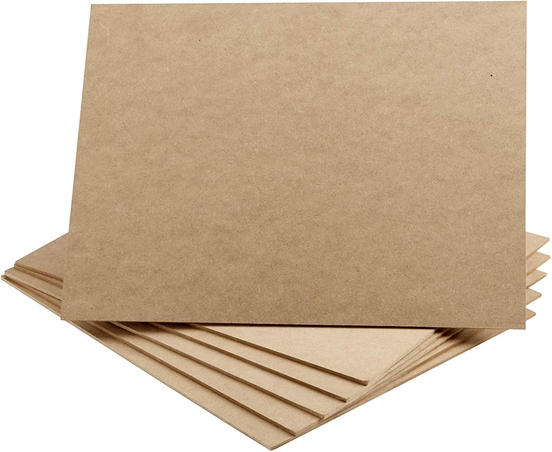 May include: A stack of rectangular, light brown MDF boards. The boards are arranged in a layered fashion, with several visible. The top board is angled upwards, showcasing the material's texture and color. The boards are likely for crafting or construction.