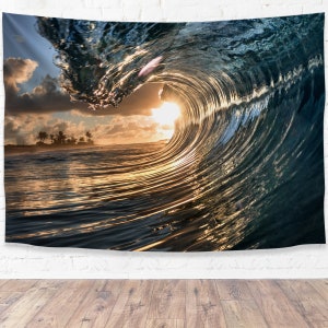 May include: A large wave breaking in the ocean at sunset. The sun is shining through the wave, creating a golden glow. The wave is a deep blue color, and the water is a light blue color.