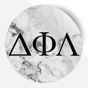 Könnte beinhalten: Ein weißer Marmorkreis mit schwarzen griechischen Buchstaben "ΔΦΛ" in der Mitte.