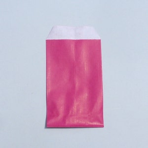 Op de afbeelding: Een roze envelop met een witte flap. De envelop heeft een subtiele glinsterende afwerking.