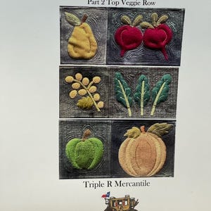May include: A fabric art piece titled "Back Road Farm" by Lucinda Shattuck, featuring six embroidered vegetable designs. The artwork includes a pear, radishes, a leafy sprig, leaves, a green apple, and a pumpkin. The text "Triple R Mercantile" and "Original Designs in Wool" are also present.