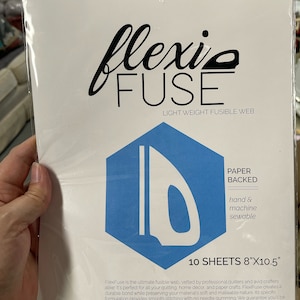 Puede incluir: Un paquete de FlexiFuse, una tela fusible ligera para acolchar y manualidades. El paquete presenta el logotipo de FlexiFuse, un hexágono azul con un gráfico de plancha y el texto "10 HOJAS 20.3cm X 26.7cm". El producto está respaldado por papel y es cosible a mano y a máquina.