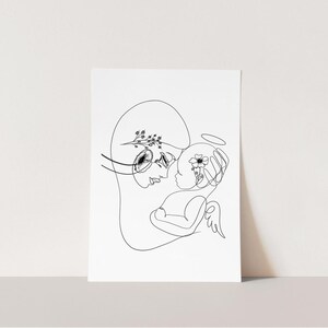 May include: A black and white line drawing of a mother and child. The mother is holding the child in her arms, and the child has a halo above its head. Both figures are adorned with delicate floral details.