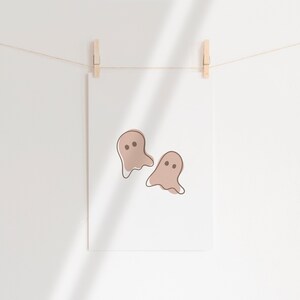Three Halloween prints. The first print features two blush colored bats, the second print is a blush colored jack’o-lantern and the third print is two adorable blush colored ghosts.