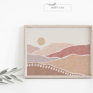 Peut inclure: Une impression d'art num&eacute;rique d'un paysage minimaliste avec un soleil, des collines et un fond beige. Les collines sont dans des tons de rose, de violet et de marron. L'impression est encadr&eacute;e dans un cadre en bois clair.