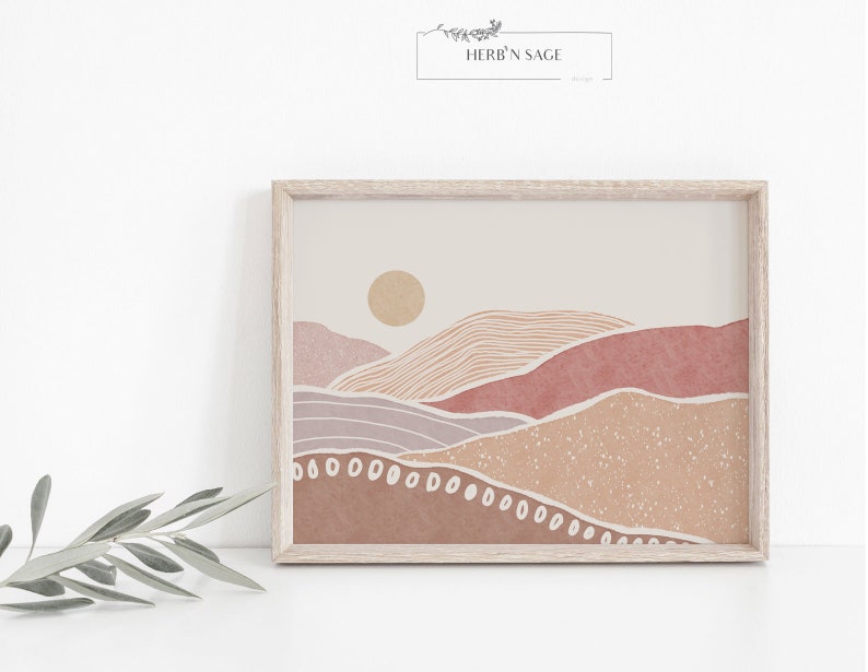 Peut inclure: Une impression d'art num&eacute;rique d'un paysage minimaliste avec un soleil, des collines et un fond beige. Les collines sont dans des tons de rose, de violet et de marron. L'impression est encadr&eacute;e dans un cadre en bois clair.