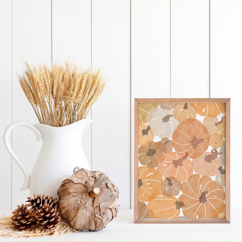 This autumn seasonal printable features scattered pumpkins painted in earthy orange, brown and yellow colors. Perfect printable art for any home this fall season!