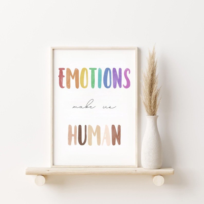 K&ouml;nnte beinhalten: Ein gerahmter Druck mit dem Text "EMOTIONS make us HUMAN" in einem Regenbogen-Farbschema. Der Text ist in einem verspielten, handgezeichneten Stil.