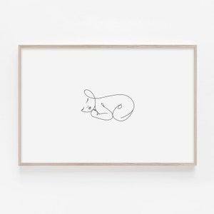 Puede incluir: Un dibujo de l&iacute;nea simple de un beb&eacute; durmiendo en un estilo minimalista. El dibujo est&aacute; en blanco y negro y est&aacute; enmarcado en un marco de madera claro.
