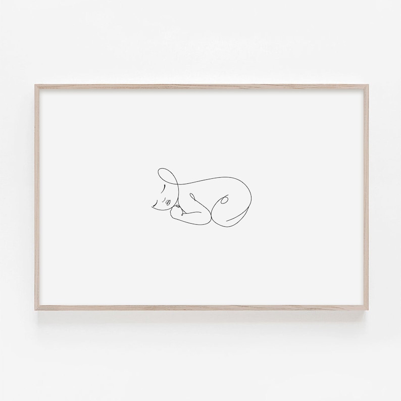 Puede incluir: Un dibujo de l&iacute;nea simple de un beb&eacute; durmiendo en un estilo minimalista. El dibujo est&aacute; en blanco y negro y est&aacute; enmarcado en un marco de madera claro.