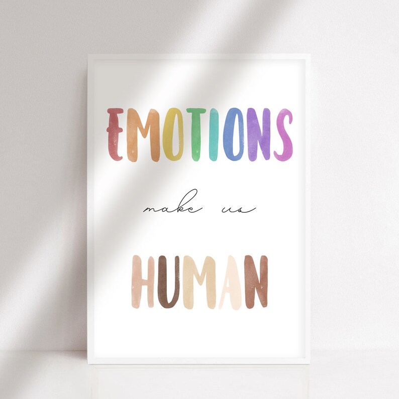 K&ouml;nnte beinhalten: Ein wei&szlig;er gerahmter Druck mit dem Text "EMOTIONS make us HUMAN" in Regenbogen- und braunen Aquarellbuchstaben.