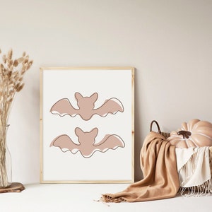 Three Halloween prints. The first print features two blush colored bats, the second print is a blush colored jack’o-lantern and the third print is two adorable blush colored ghosts.