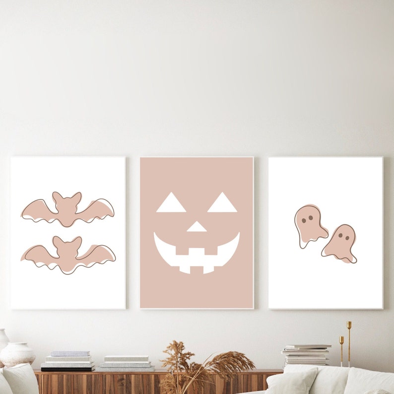 Three Halloween prints. The first print features two blush colored bats, the second print is a blush colored jack’o-lantern and the third print is two adorable blush colored ghosts.