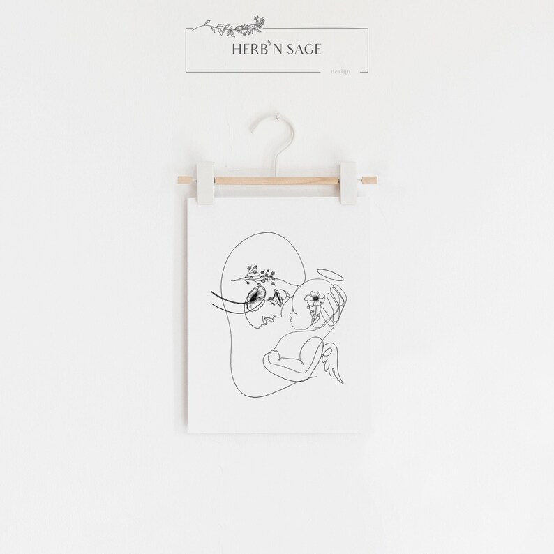 May include: Black and white line art print of a mother and child. The mother is holding the child, who has a halo above their head. The mother has flowers in her hair. The print is titled "Herb'n Sage" and is on a white background.