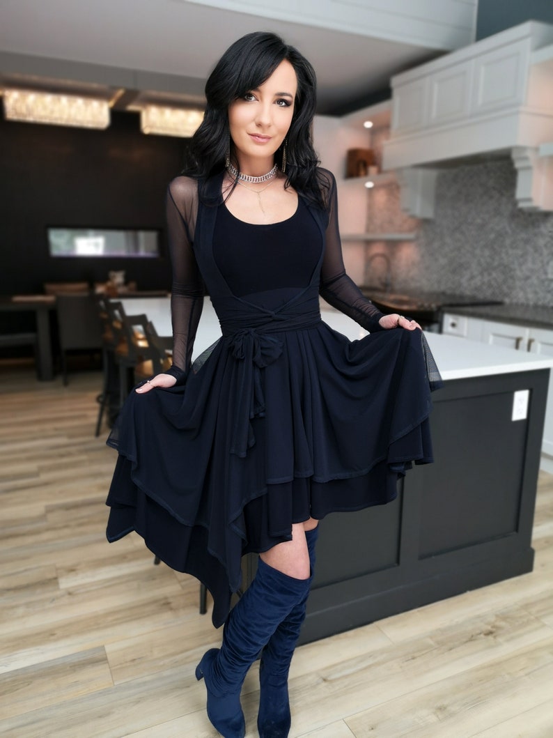 Short flowy dress. This navy dress is classic and fun with a double layer circle skirt and unsymmetrical hemline. Jackets sold separately.