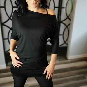 Black 3/4 sleeve long drapey tunic top with. This piece is drapey on one side and more fitted on the other. sweater shirt dress, tunic top