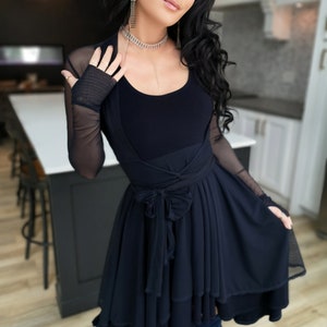 Short flowy dress. This navy dress is classic and fun with a double layer circle skirt and unsymmetrical hemline. Jackets sold separately.