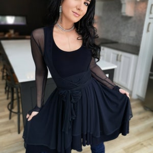 Short flowy dress. This navy dress is classic and fun with a double layer circle skirt and unsymmetrical hemline. Jackets sold separately.