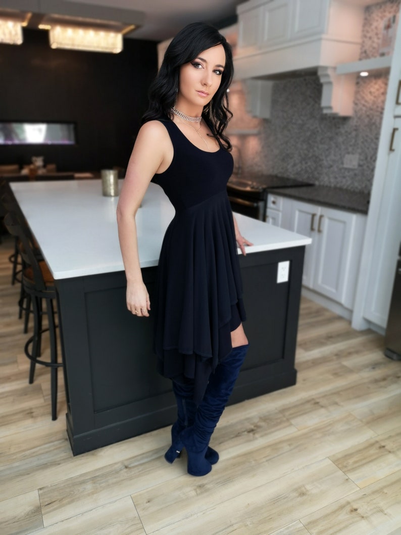Short flowy dress. This navy dress is classic and fun with a double layer circle skirt and unsymmetrical hemline. Jackets sold separately.