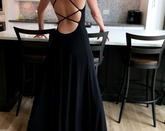 This expose black long cowl neck maxi dress is all about making a bold statement. Featuring a cowl neck and a dramatic deep low back.