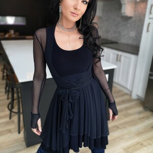 Short flowy dress. This navy dress is classic and fun with a double layer circle skirt and unsymmetrical hemline. Jackets sold separately.