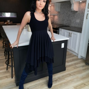 Short flowy dress. This navy dress is classic and fun with a double layer circle skirt and unsymmetrical hemline. Jackets sold separately.
