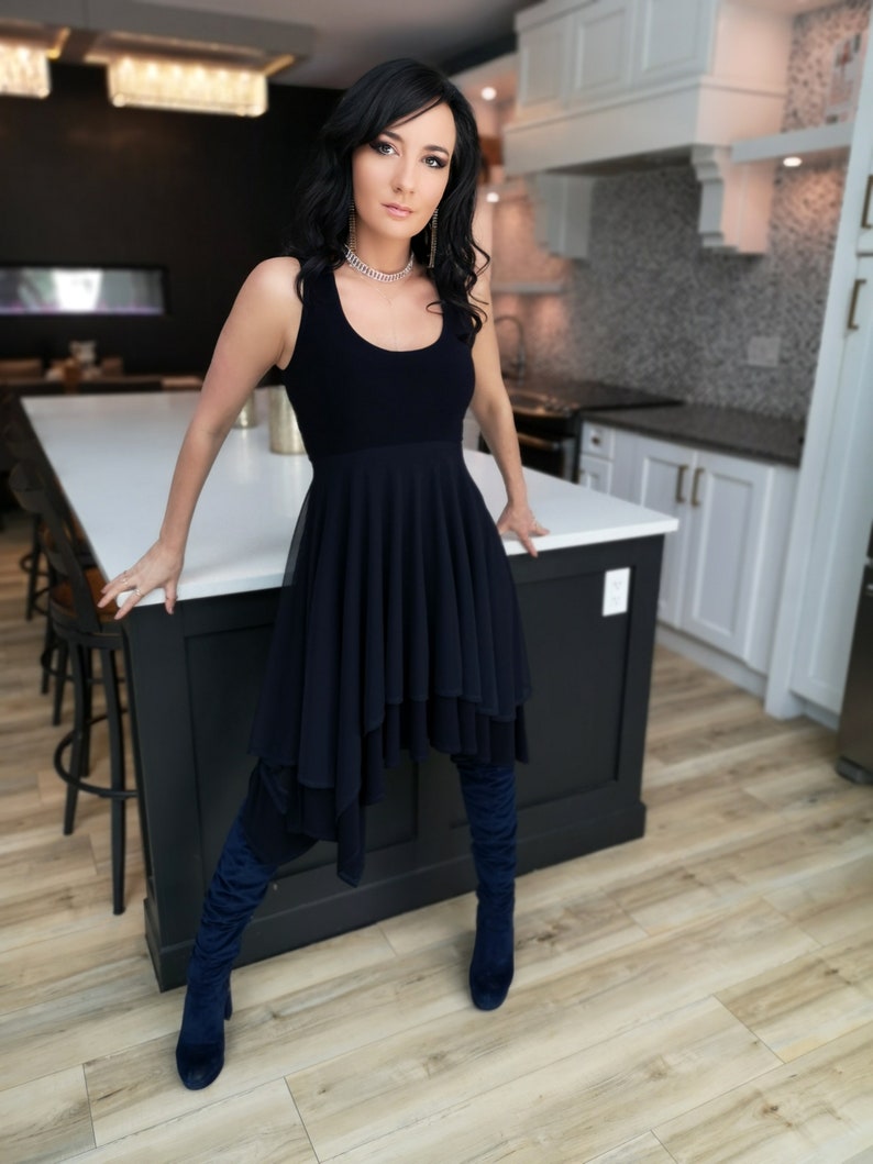Short flowy dress. This navy dress is classic and fun with a double layer circle skirt and unsymmetrical hemline. Jackets sold separately.