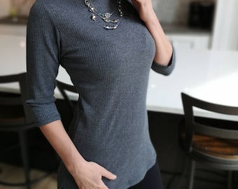 Gray boat neck ribbed top. This top is fitted throughout with a 3/4 sleeve.