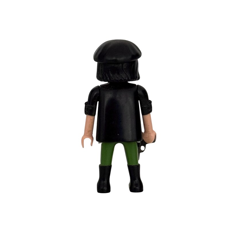 May include: A black plastic toy figure wearing a black beret, a black jacket, green pants, and black boots.