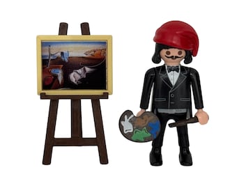 May include: A miniature figurine of an artist wearing a black suit and a red beret, holding a paint palette and a brush, standing in front of an easel with a painting of a melting clock on it.