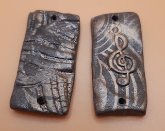 Charms van Arabesque en solsleutel, handgemaakt in polymeerklei voor het maken van oorbellen.