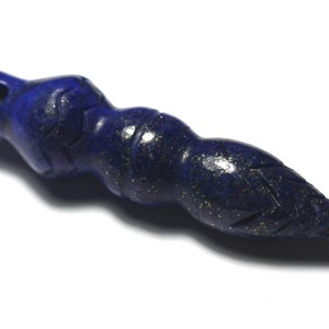 May include: A dark blue lapis lazuli pendant carved in the shape of a stylized bird with gold flecks throughout the stone.