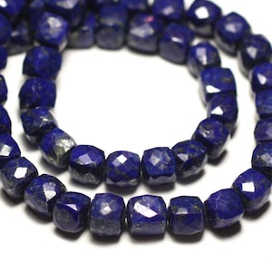 Könnte beinhalten: Eine Kette aus tiefblauen Lapislazuli-Edelsteinen. Die Perlen sind facettiert und haben eine quadratische Form.