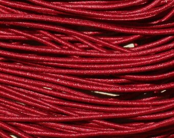 May include: A close-up of a spool of red elastic cord. The cord is made of a soft, stretchy material and is perfect for crafting projects.