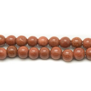 May include: A strand of brown sandstone beads. The beads are round and have a smooth, polished finish.
