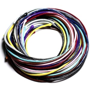 Puede incluir: Una colección de cordones encerados de colores, en una variedad de colores, incluyendo negro, blanco, rojo, amarillo, azul y verde, están agrupados en un círculo.